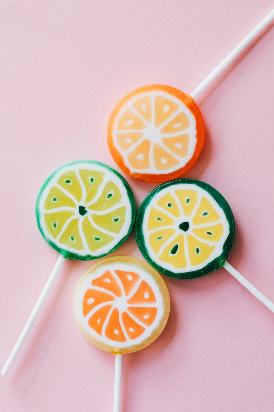 Different sweet lollipops on pink background