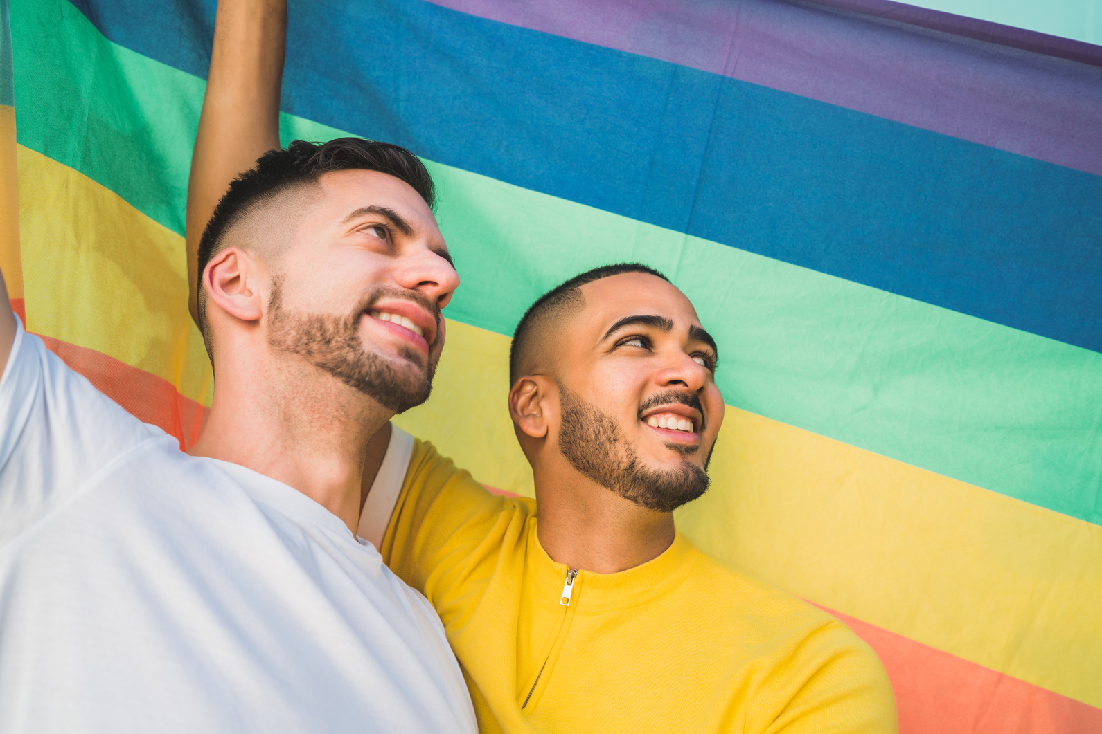 Gay Couple Embracing and Showing Their Love with Rainbow Flag