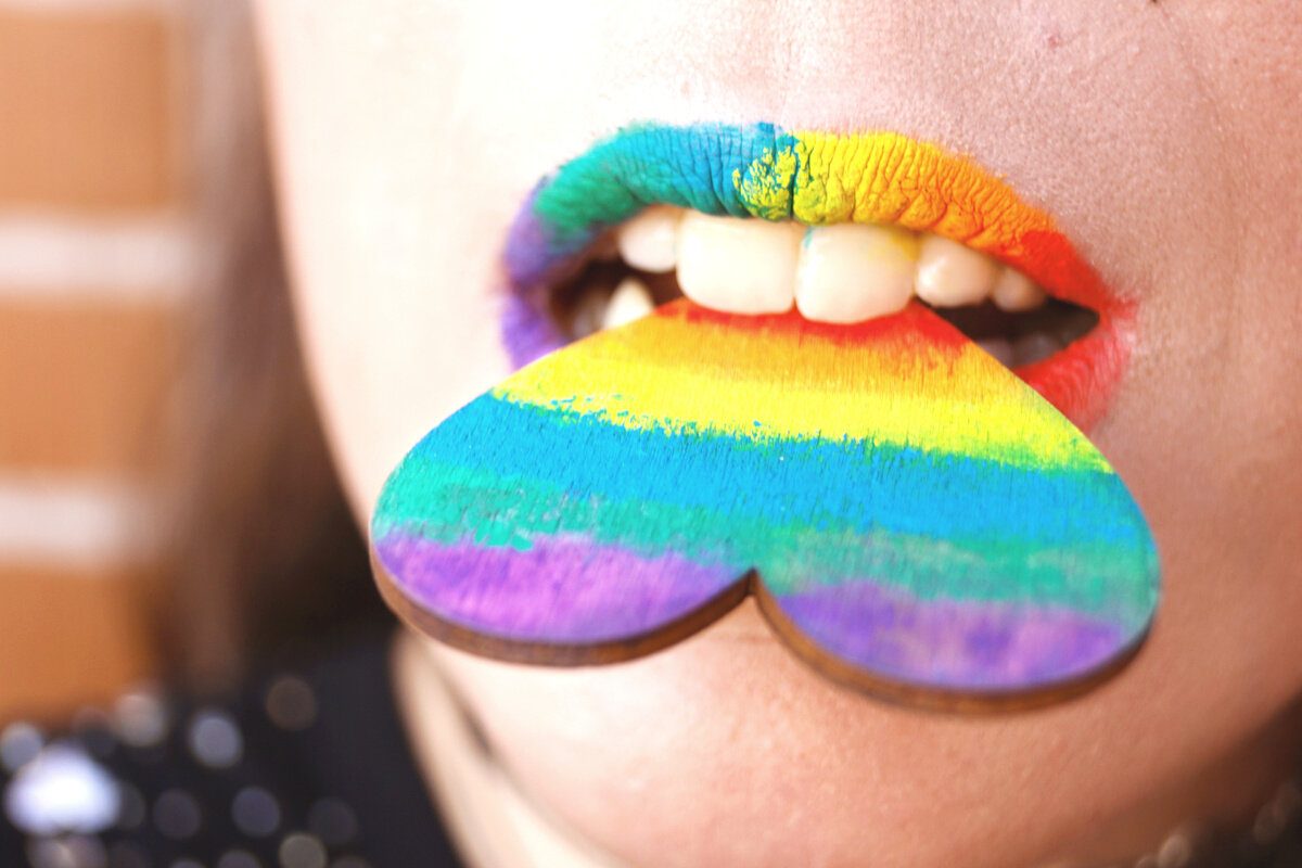 Person Biting Multicolored Heart Decor