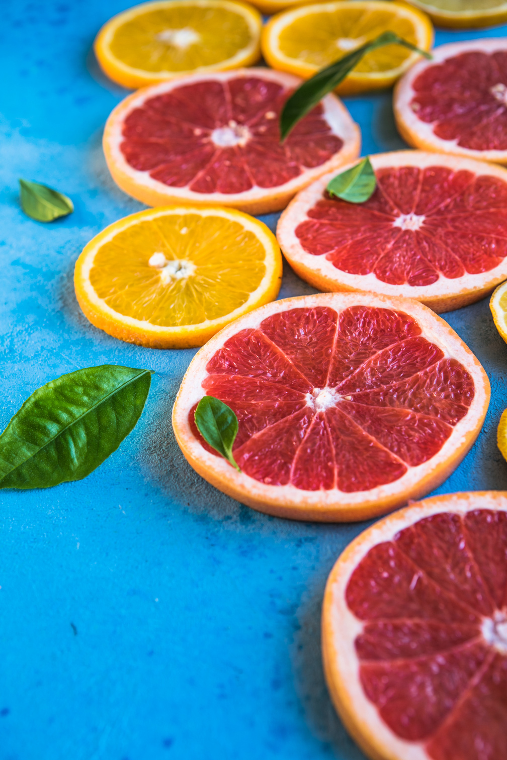 Vibrant colored citrus fruit on blue table